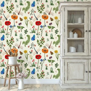 May include: A cream-colored wallpaper with a floral pattern featuring red, orange, yellow, and blue flowers, green leaves, and blue butterflies.  The wallpaper is in a kitchen setting with a white cabinet in the background.