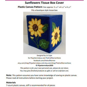 May include: A plastic canvas pattern for a sunflower tissue box cover. The pattern is designed for a tissue box that measures 13.3 cm by 11.4 cm by 11.4 cm. The pattern features two sunflowers with yellow petals and brown centres, green leaves, and a blue background.