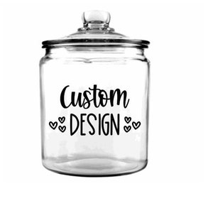 May include: A clear glass jar with a lid and a black vinyl sticker that says "Custom Design" with hearts on either side of the word "Design".