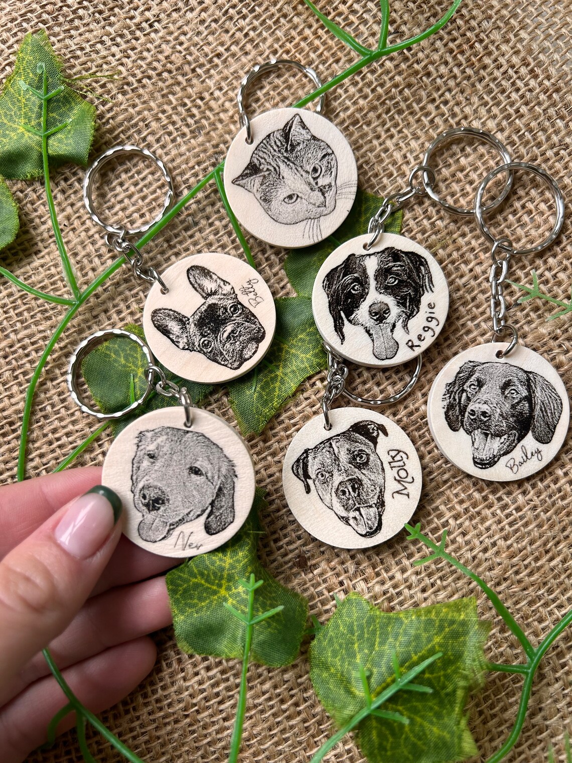 Five engraved wooden keyrings of pets and their names.
