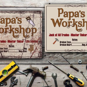 May include: Two rustic metal signs with the text "Papa's Workshop" in brown lettering. The signs have a distressed look and feature a hammer, saw, and teddy bear. The text below the title reads "Jack of All Trades - Master Tinker - Life Advice" and lists "Broken Toys" and "Broken Heart" with rates of "Hug" and "Hug + Kiss".