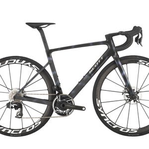 Può includere: Bicicletta da strada nera e grigia con scritte bianche sulle ruote. La bici ha un design elegante con manubrio da corsa e freni a disco. Il telaio è grigio scuro con un motivo sottile. Le ruote sono nere con scritte bianche "SYNCROS".