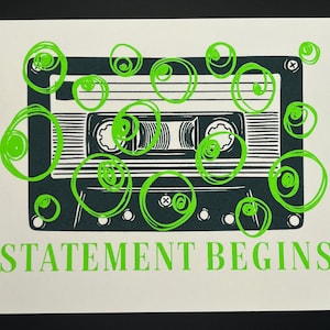 May include: A black and white cassette tape illustration with neon green scribbles and the words "STATEMENT BEGINS" printed in neon green. The image is on a white background.