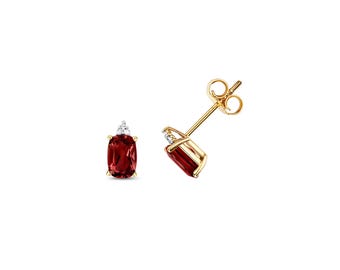 May include: A pair of gold stud earrings, each featuring a rectangular, deep red gemstone and a small, clear diamond accent. The earrings are set against a white background, highlighting their elegant design.