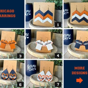 May include: A collection of seven pairs of earrings displayed on brown cards. Designs include chevron patterns in navy, orange, and white, jersey-shaped earrings with the text Chicago, and teardrop shapes featuring heart graphics and the word Chicago.