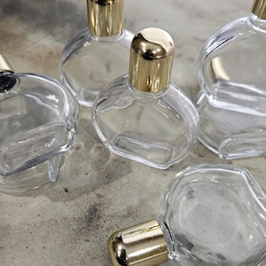 one vintage round glass perfume bottle with plastic gold tone cap