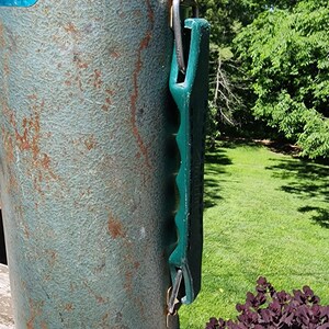 May include: Vintage Stanley thermos in a weathered teal finish with a green handle. The metal exterior shows signs of age with rust-colored spots. The thermos has a silver base and a blue and white label.