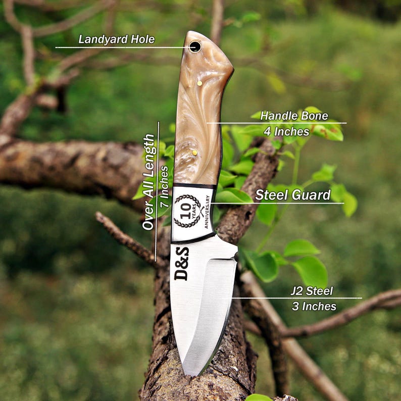 May include: A fixed-blade knife with a 4-inch bone handle, a steel guard, and a 3-inch J2 steel blade. The total length is 7 inches. The blade features the text D&S and a 10-year anniversary logo. A lanyard hole is located at the top of the handle.