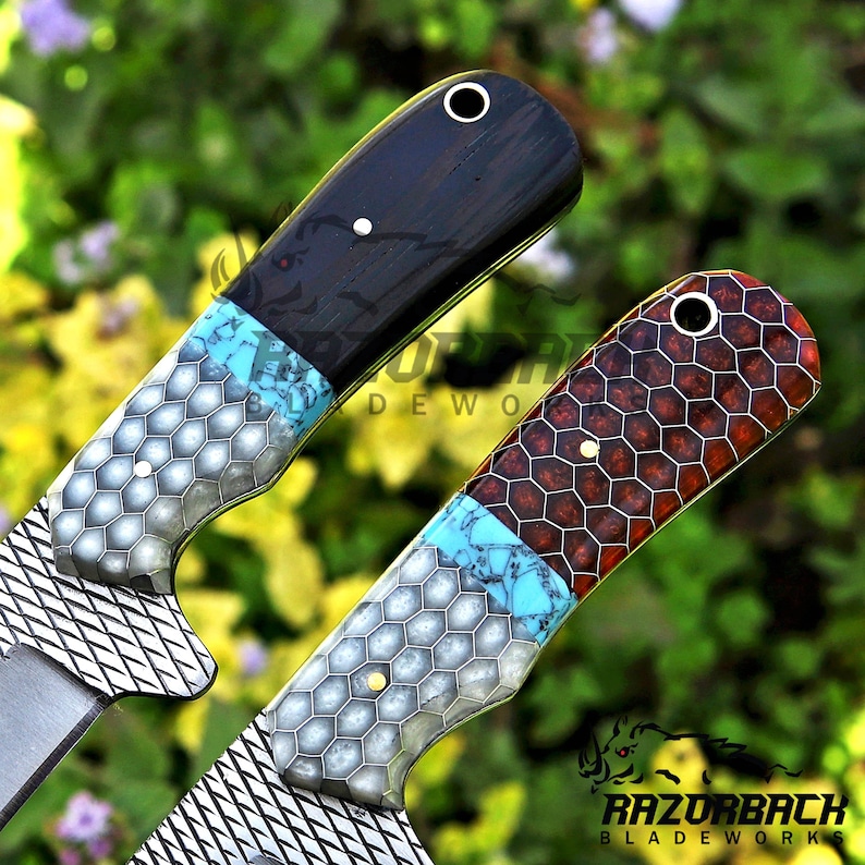 K&ouml;nnte beinhalten: Zwei Messergriffe mit einem Materialmix-Design, bestehend aus einem silbernen Wabenmuster, einem Band aus t&uuml;rkisfarbenem Stein und einem dunklen Holz- oder Harzabschnitt. Jeder Griff verf&uuml;gt &uuml;ber einen Metallstift und eine Fangriemen&ouml;se.