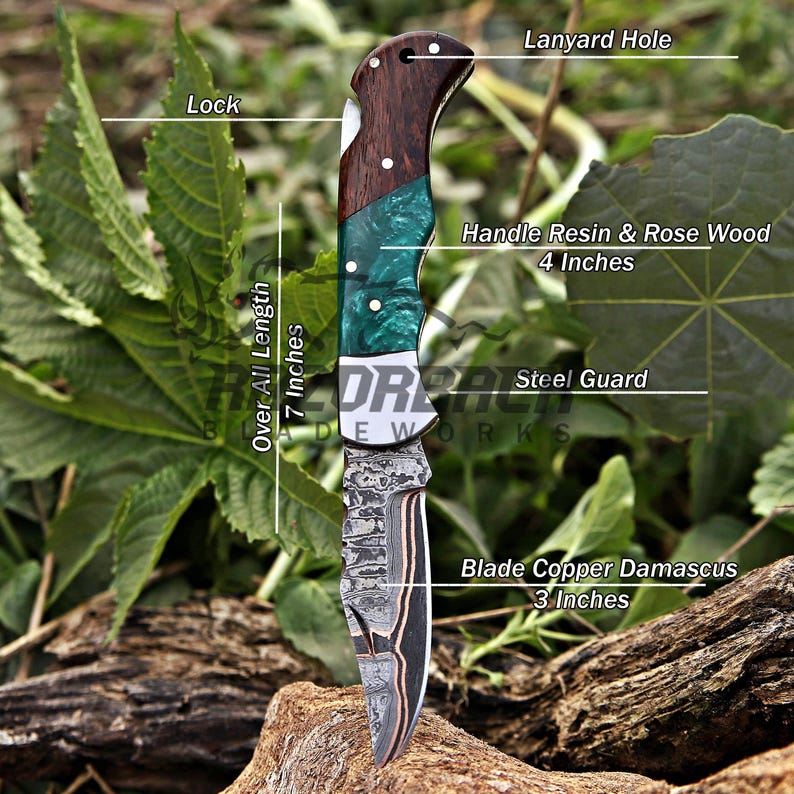 May include: A folding knife with a 3-inch copper Damascus blade, a steel guard, and a 4-inch handle made of rosewood and green resin. The knife features a lock mechanism and a lanyard hole, with an overall length of 7 inches as labeled.