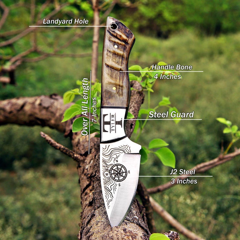 May include: A fixed-blade knife with a 4-inch bone handle, a steel guard, and a 3-inch J2 steel blade featuring a compass and topographic map engraving. The knife has a lanyard hole and an overall length of 7 inches, with the text TYLER on the bolster.