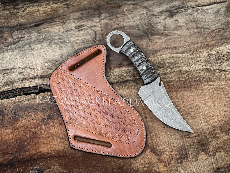 handmade damascus hunting skinner knife with wood handle and leather sheath, the knife is perfect for outdoors, the knife is built as a utility knife and has a finger hole which makes it perfect for survival in the outdoors, the sheath and the knife is what makes it a perfect bush craft knife.
