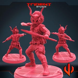 Könnte beinhalten: Drei rote Plastik-Miniaturfiguren von Kriegern mit gehörnten Helmen und Waffen. Die Figuren stehen auf runden Sockeln. Der Text "TRIDENT STUDIO" ist im Hintergrund sichtbar.