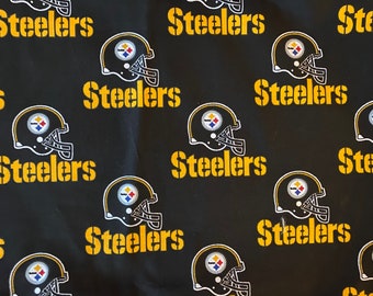 May include: Black fabric with a repeating pattern of yellow "Steelers" text and a black and gold football helmet.