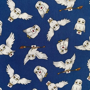 May include: A blue fabric with a repeating pattern of white owls carrying letters and a brown twig. The owls have yellow eyes and are flying.