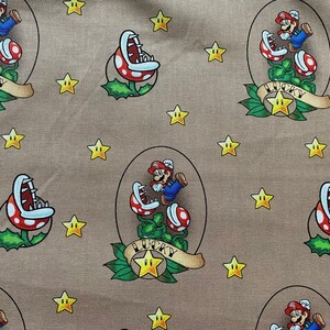 May include: A brown fabric with a repeating pattern of a cartoon character, a plant, and stars. The character is wearing a red cap and blue overalls. The plant is green with red and white flowers. The stars are yellow. The text "LUCKY" is printed on the fabric.