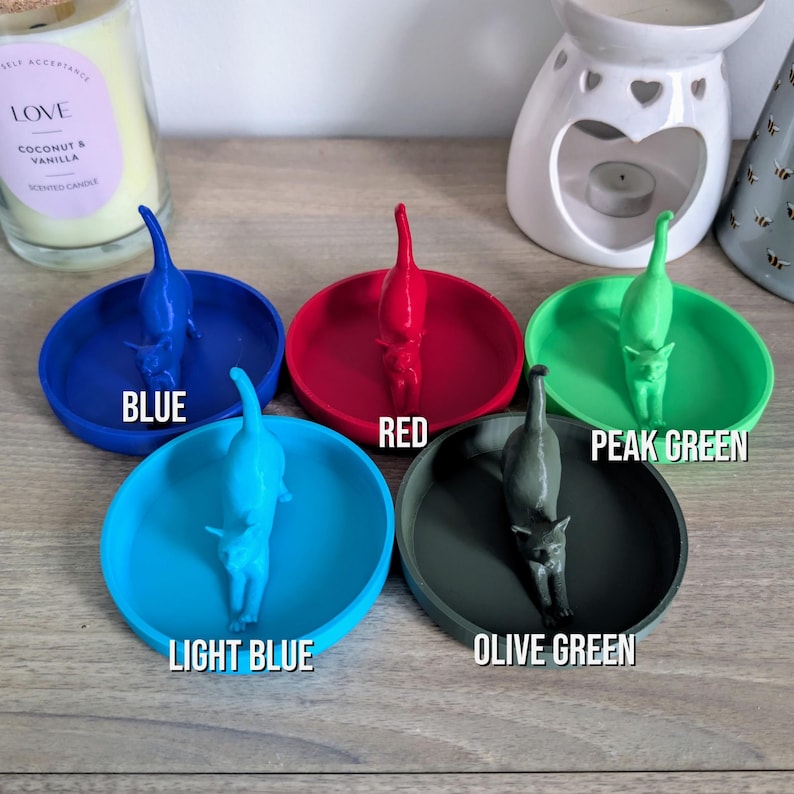 May include: Five ring dishes in different colors: blue, red, light blue, olive green, and peak green. Each dish features a 3D printed cat figurine.