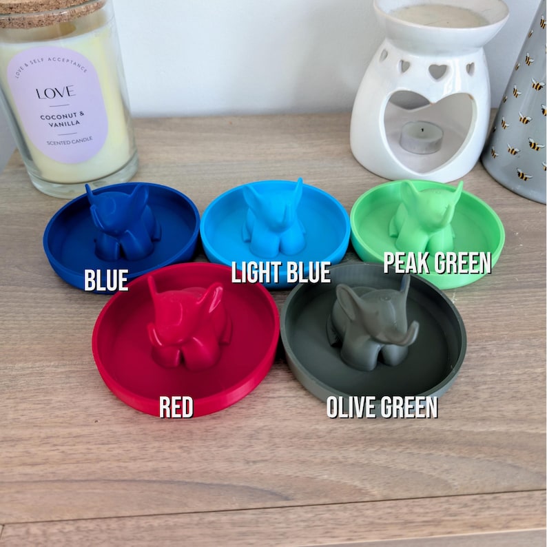 May include: Five small ceramic elephant ring dishes in different colors: blue, light blue, peak green, red, and olive green.
