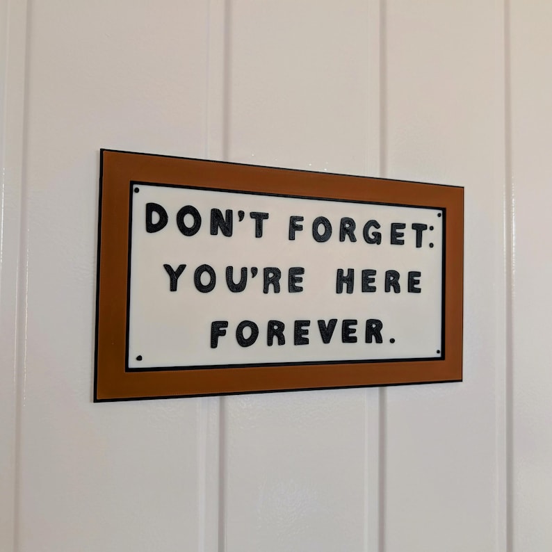 May include: A brown wooden sign with white lettering that reads "Don't forget: You're here forever."