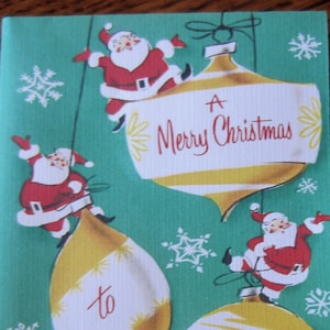 May include: A vintage Christmas card with a green background and three ornaments. The ornaments are decorated with gold and white stripes and have the text "A Merry Christmas to You".