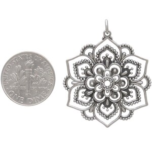 Mandala pendant with soldered jump ring next to a dime for size reference