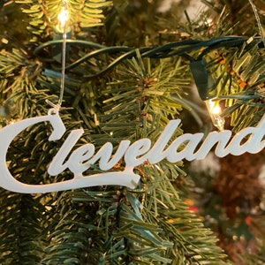 Può includere: Addobbo natalizio bianco con la parola "Cleveland" scritta in corsivo.