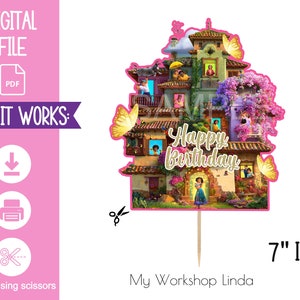 May include: A printable 7-inch cake topper featuring a colourful illustration of a house with a pink roof and a family of characters from the animated film Encanto. The text "Happy Birthday" is written in gold lettering on the house.