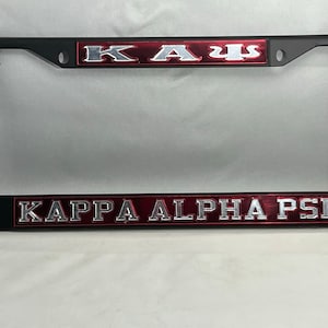 May include: Black license plate frame with red and silver lettering that reads "Kappa Alpha Psi".