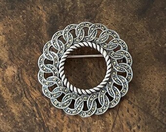 Broche vintage Judith Jack em prata de lei brilhante com marcassita e formato de círculo infinito.