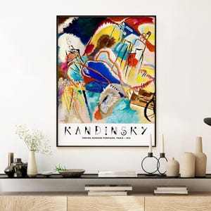 May include: A poster featuring an abstract painting by Wassily Kandinsky. The painting is a vibrant mix of colors, including blue, yellow, red, and green. The title "Kandinsky" is printed in black at the bottom of the poster, along with the text "Centre Georges Pompidou, Paris - 1913".