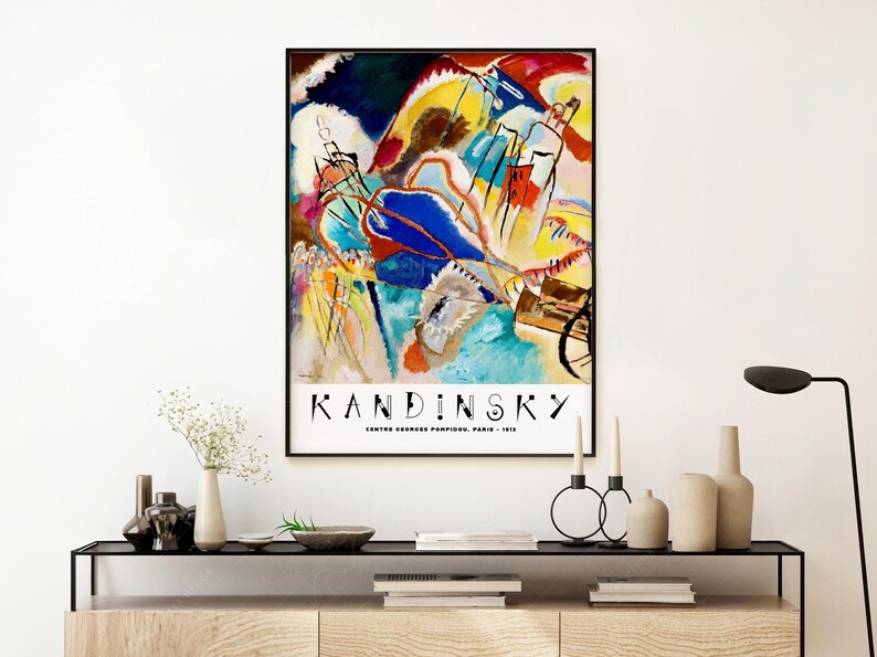 May include: A poster featuring an abstract painting by Wassily Kandinsky. The painting is a vibrant mix of colors, including blue, yellow, red, and green. The title "Kandinsky" is printed in black at the bottom of the poster, along with the text "Centre Georges Pompidou, Paris - 1913".