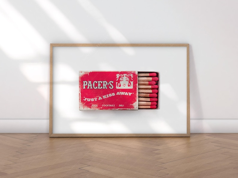 K&ouml;nnte beinhalten: Gerahmter Druck mit einer roten Vintage-Streichholzschachtel mit dem Text "PACER'S JUST A KISS AWAY". Die Schachtel ist ge&ouml;ffnet und zeigt Streichh&ouml;lzer mit roten K&ouml;pfen. Der Hintergrund ist wei&szlig;.