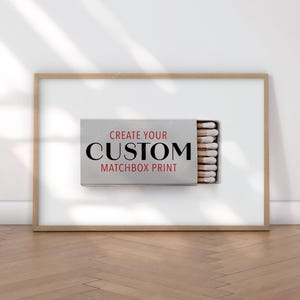 K&ouml;nnte beinhalten: Gerahmter Druck mit Streichholzschachtel-Design. Die Streichholzschachtel ist ge&ouml;ffnet und zeigt Streichh&ouml;lzer. Der Text "CREATE YOUR CUSTOM MATCHBOX PRINT" ist in Schwarz und Rot dargestellt. Der Rahmen ist hellbraun.