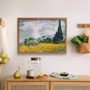 Pu&ograve; includere: Un dipinto incorniciato che rappresenta un paesaggio con un campo giallo, alberi verdi e un cielo blu con nuvole bianche. Il dipinto &egrave; in una cornice di legno.