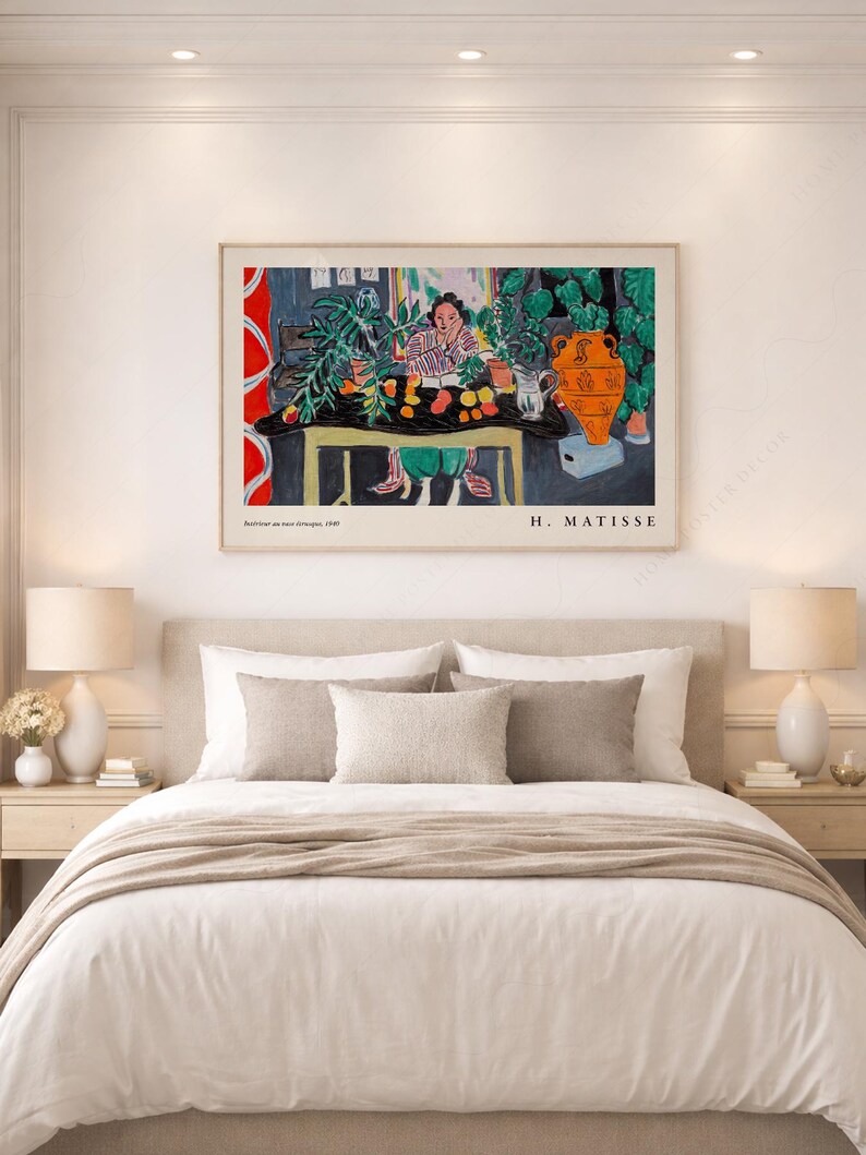 May include: A framed art print of Henri Matisse's painting titled Int&eacute;rieur aux aubergines, 1948. The artwork depicts a person sitting at a table with a black cloth, green plants, an orange vase, and fruit, with the text H. MATISSE at the bottom.