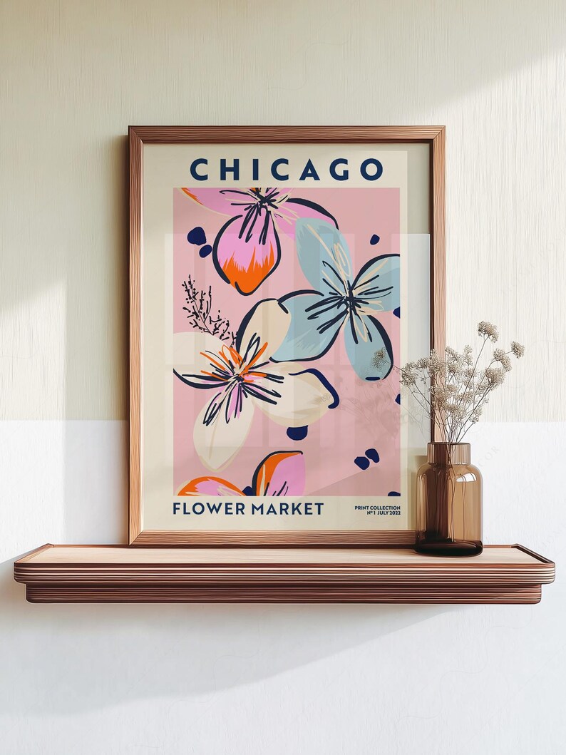 May include: A framed wall art print titled CHICAGO FLOWER MARKET with a pink background and abstract floral illustrations in shades of blue, orange, and cream. The text includes PRINT COLLECTION N&deg;1 JULY 2023 in the bottom right corner.