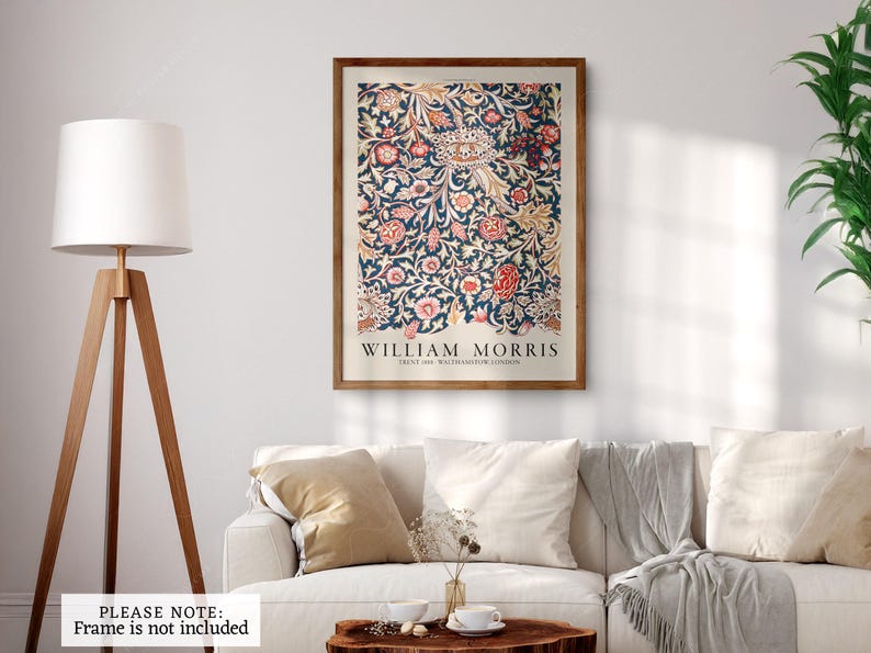 Pu&ograve; includere: Una stampa artistica incorniciata con un design floreale nei toni del blu, rosso e crema. La stampa, con il testo "WILLIAM MORRIS", &egrave; esposta sopra un divano bianco. La cornice &egrave; di un caldo colore marrone, che completa l'opera.