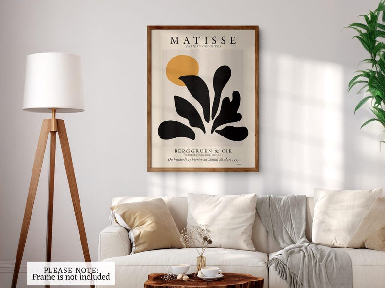 May include: A rectangular wall art print featuring a Matisse Papiers D&eacute;coup&eacute;s exhibition poster. The design includes a yellow circle above abstract black organic shapes on a cream background, with text reading MATISSE, BERGGRUEN & CIE.