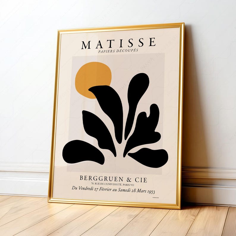 May include: A framed wall art print featuring the text MATISSE PAPIERS D&Eacute;COUP&Eacute;S at the top and BERGGRUEN & CIE 70, RUE DE L'UNIVERSIT&Eacute;, PARIS-VII Du Vendredi 27 F&eacute;vrier au Samedi 28 Mars 1953 at the bottom, with a yellow circle and black organic shapes.