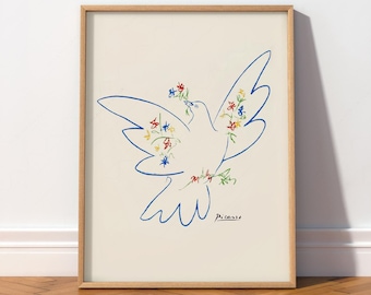 Op de afbeelding: Een ingelijste kunstdruk met een blauwe lijntekening van een vliegende duif, die kleine kleurrijke bloemen in de snavel en rond het lichaam houdt. De achtergrond is crèmekleurig en de handtekening Picasso staat in het zwart onderaan.