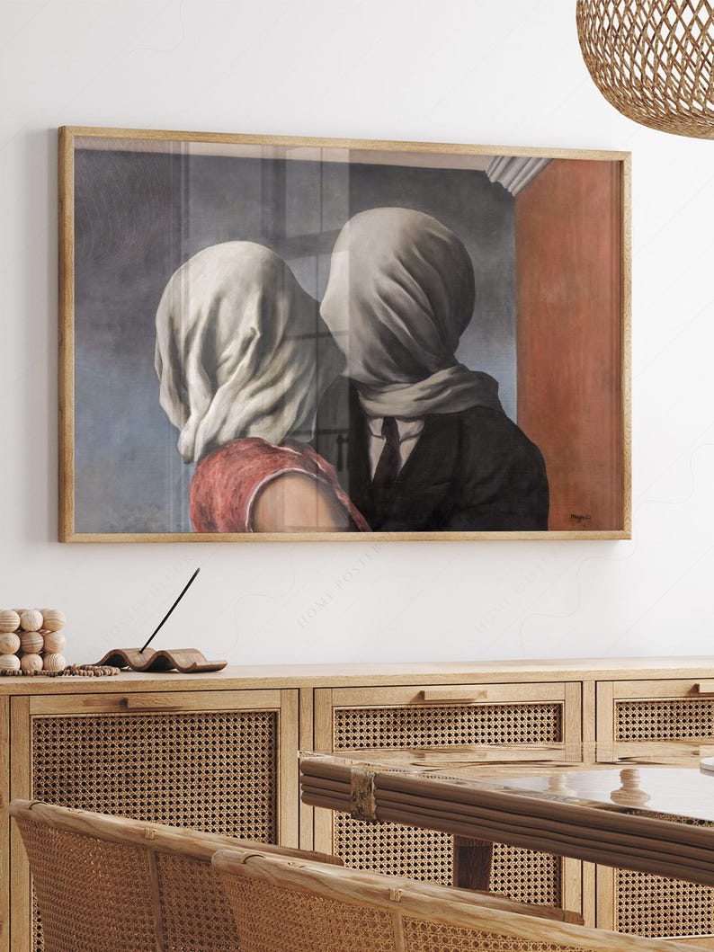 May include: A framed rectangular wall art print depicting two figures with their heads covered in white fabric. The figure on the left wears a red garment, while the figure on the right wears a dark suit and tie. The background features a blue wall.
