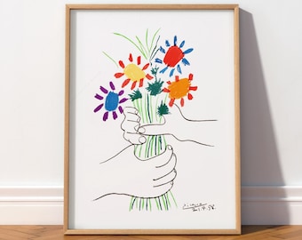 May include: A framed art print featuring a black line drawing of two hands holding a bouquet of colorful flowers. The flowers are rendered in red, yellow, blue, orange, and green. The signature Picasso 21.4.58 is visible in the bottom right corner.