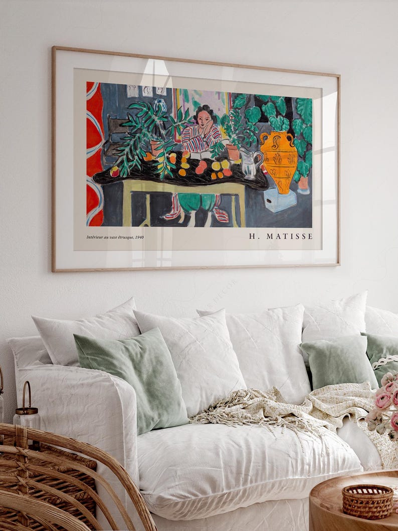May include: A framed art print of Henri Matisse's Int&eacute;rieur aux aubergines, 1940. The painting depicts a person sitting at a table with a black cloth, green plants, a yellow vase, and fruit. The text reads Int&eacute;rieur aux aubergines, 1940 and H. MATISSE.