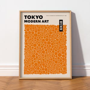 Peut inclure: Une affiche encadrée présentant le texte TOKYO MODERN ART et TOKYO'S MUSEUM OF CONTEMPORARY ART - 1998 en noir. Le design comprend un rectangle noir vertical avec des caractères japonais et un grand bloc central de cercles orange de tailles variées.