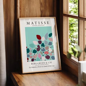 Henri Matisse Modern abstract art featuring a vibrant composition of soft, rounded shapes in shades of teal, coral, and deep burgundy, interspersed with muted pastels. The artwork exudes a playful yet sophisticated mood, with organic forms creating a sense of movement and flow across the canvas. Subtle textures and layered colors enhance the depth, inviting viewers to explore the interplay of light and shadow. Elegantly displayed on a living room wall, this printed poster wall art beautifully