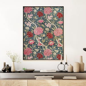 May include: A framed print of a vintage floral pattern featuring pink and red flowers on a dark blue background. The flowers are stylised and have a repeating pattern.