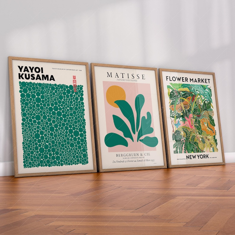 May include: Three framed art prints displayed side-by-side. The first features Yayoi Kusama with green dots on a white background. The second shows a Matisse Papiers D&eacute;coup&eacute;s design with a yellow sun and green leaves. The third is a Flower Market New York print.