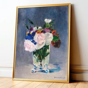 Impressionist floral still life featuring vibrant bouquet of soft pink peonies, deep blue irises, and bright orange marigolds arranged in clear glass vase, set against moody, textured slate-blue background. The brush strokes are loose and dynamic, creating sense of movement and life within the composition. The light reflects delicately off the vase, enhancing the freshness of the flowers. 'Bouquet' by Edouard Manet framed and displayed on living room wall. Printed poster wall art.