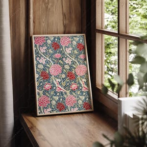 May include: A framed print with a floral pattern featuring pink and red flowers on a dark blue background.