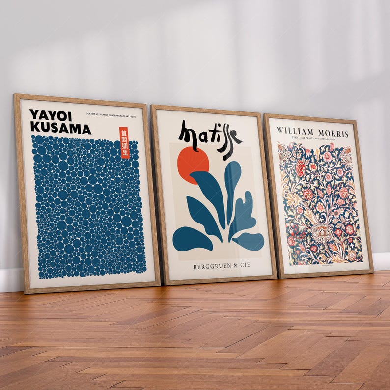 May include: Three framed art prints with different styles. The left print features a blue and white pattern of circles with the text "Yayoi Kusama". The middle print features a blue and white abstract design with a red circle and the text "matisse" and "Berggruen & Cie". The right print features a floral pattern with the text "William Morris".